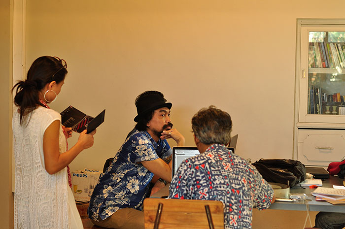 Rekaman suasana pengerjaan desain dan tata letak. Ayip (memunggungi kamera) barangkali menyangka saya sedang berpikir tentang masukan apa yang bisa saya berikan untuk desain dan tata letak. Padahal saya sedang membayangkan, "Wah, makan sate kambing terus lanjut bir dingin kayaknya enak neh..." | Foto: Sam Bonaventura.